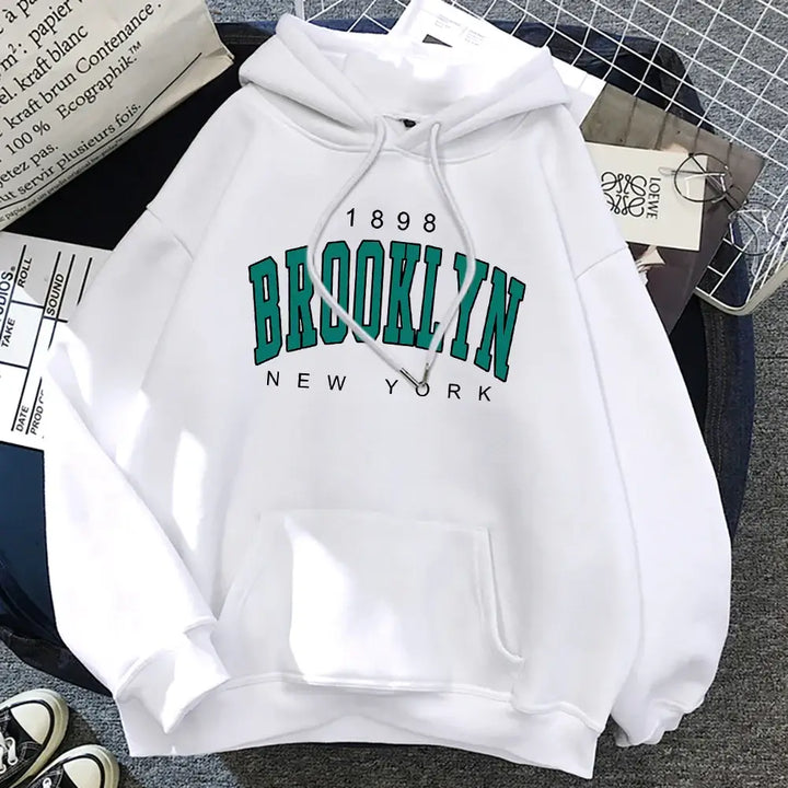 White Brooklyn hoodie featuring a striking print, perfect for unisex street fashion and everyday wear.